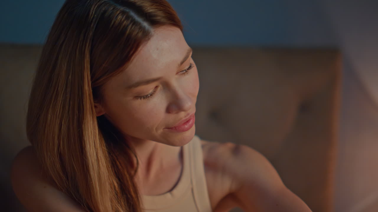 Lady massaging arms skin with body lotion at evening lamp light close up.