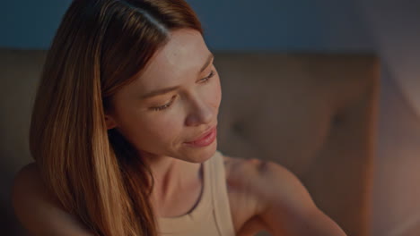 lady massaging arms skin with body lotion at evening lamp light close up.