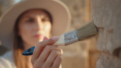 mujer conservando una antigua escultura de piedra