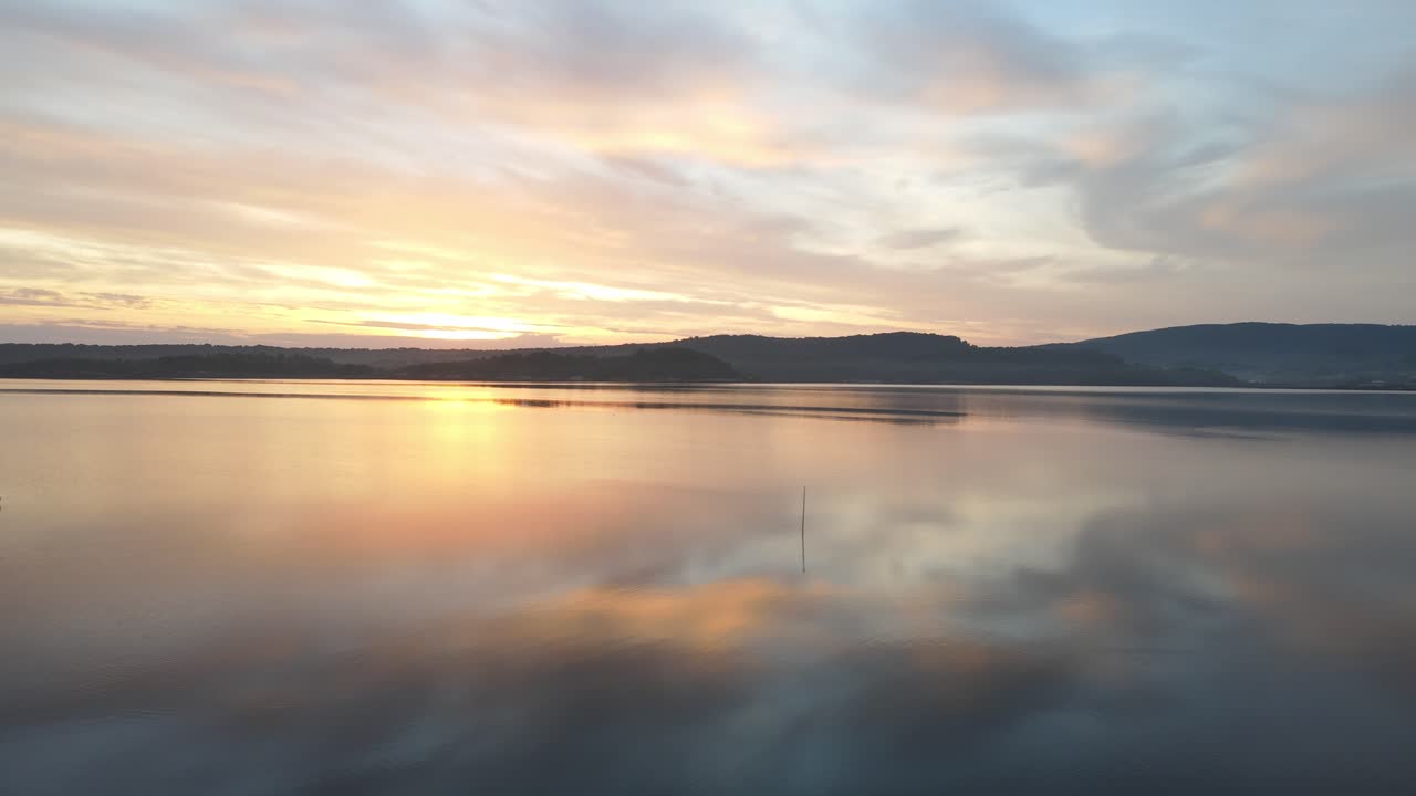 agua cristalina con reflejo de la puesta de sol en la bahía de fornells en menorca, españa