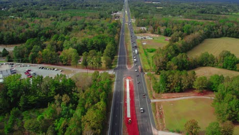 following wood carrier cargo vessel truck trailer enters frame with big timber pine, spruce, cedar driving on highway