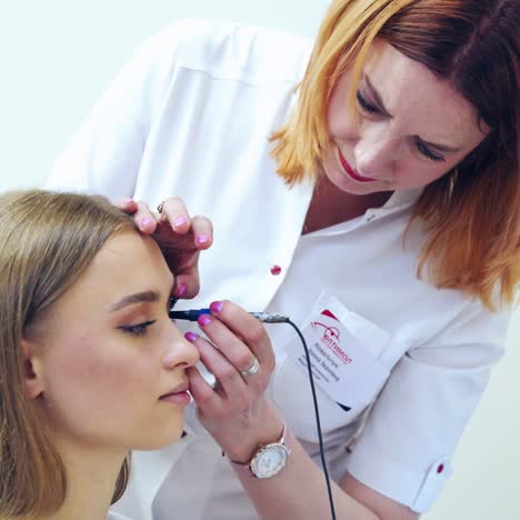 young female visiting ophthalmologist. professional doctor treating eyes to a woman and using special medical device. eyesight concept.