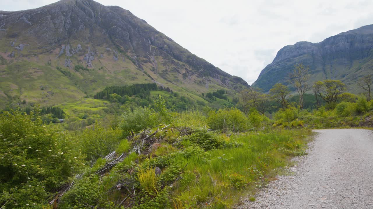 camino de ripio que conduce al valle de la montaña glencoe en escocia