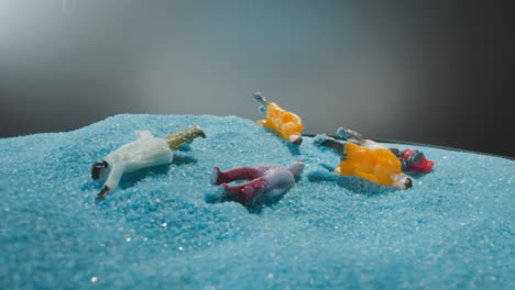 artificial figurines with bags falling on soft blue sand