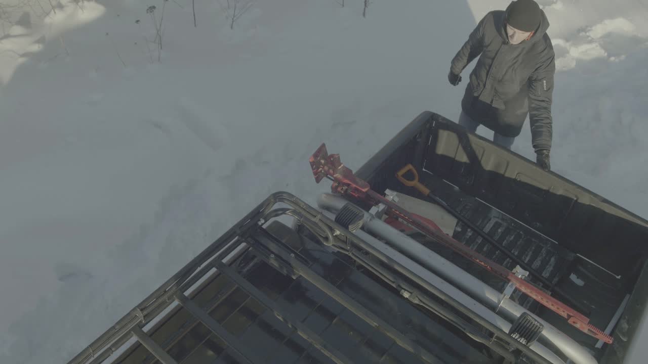 트럭과 도구로 눈 인 풍경에서 겨울을 준비하는 남자