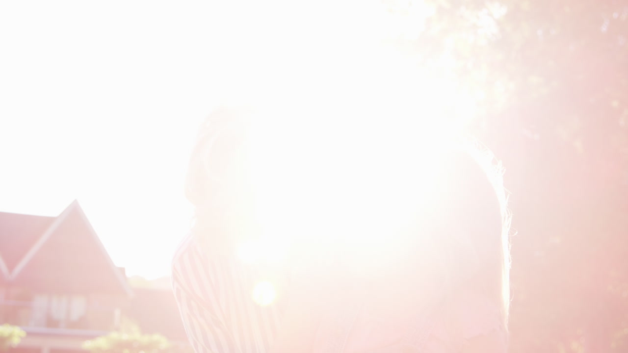 할머니는 여름 술집의 정원에서 손녀를 안고 있습니다.