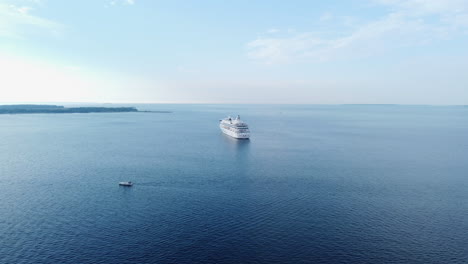 aerial seascape with cruise ship and small boat sailing, sunny day