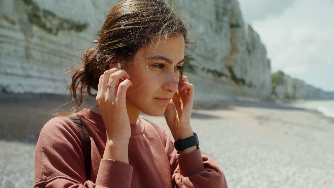 Donna che si gode la spiaggia con gli auricolari