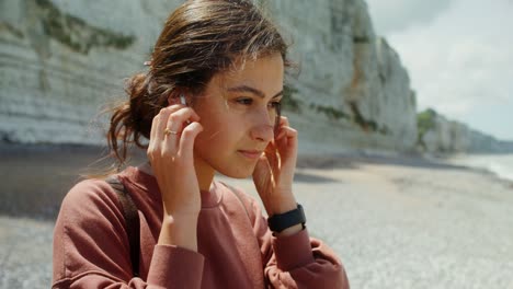 woman enjoying the beach with earbuds