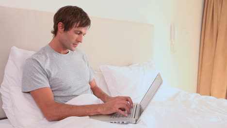 Smiling-man-using-his-laptop