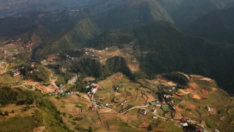 una toma aérea pintoresca mira cuesta abajo a un valle de tierras de cultivo en las montañas del sudeste asiático
