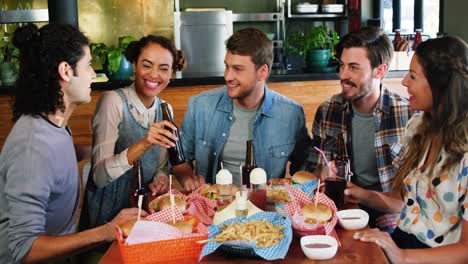 amigos comiendo hamburguesas y bebidas en un restaurante