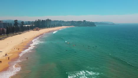 aerial view group of surfers paddling on surfboards on waves in the ocean at beautiful beach. enjoying outdoor activity lifestyle water sport surfing on summer holiday. manly beach, sydney, australia