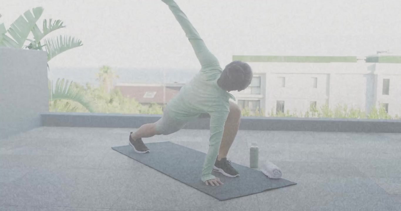 Female exerciser starting from low runner's lunge on yoga mat, rotating torso for fitness mobility