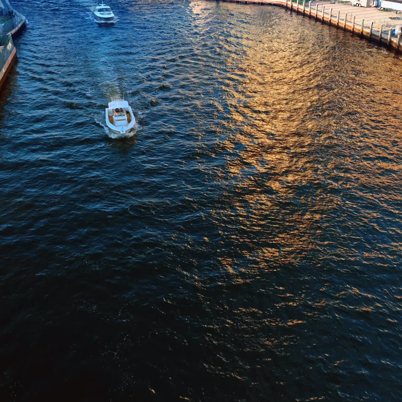 Couple of white motor boats sailing by the river. Drone footage above the Miami River at daytime.
