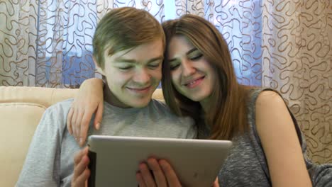 una pareja joven viendo la tableta.