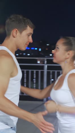 couple dancing at night on a balcony