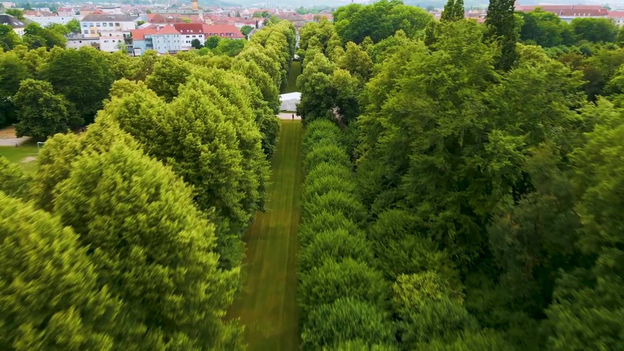 4K letecké video z dronu: Cesty lemované stromy v zahradě Hofgarten v centru Ansbachu, Německo.