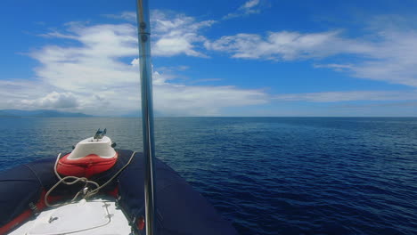 pov-aufnahme vor einem kleinen boot, das auf eine ferne tropische insel zusteuert