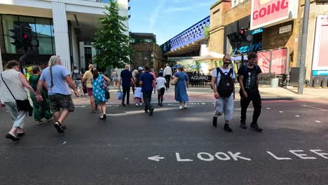 pedestrians crossing a busy street in london