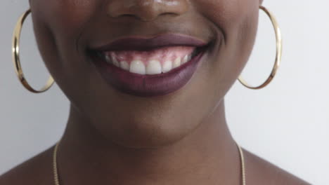 Cerca-De-Los-Labios-De-Una-Mujer-Afroamericana-Sonriendo-Feliz-Mostrando-Dientes-Sanos-Hermosa-Piel-Perfecta-Aretes-Dorados