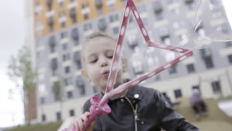 niño soplando burbujas en un parque de la ciudad