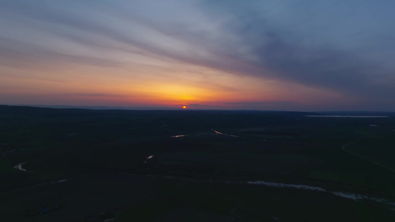 Evening glow spreads across Romanian plains beneath layered clouds
