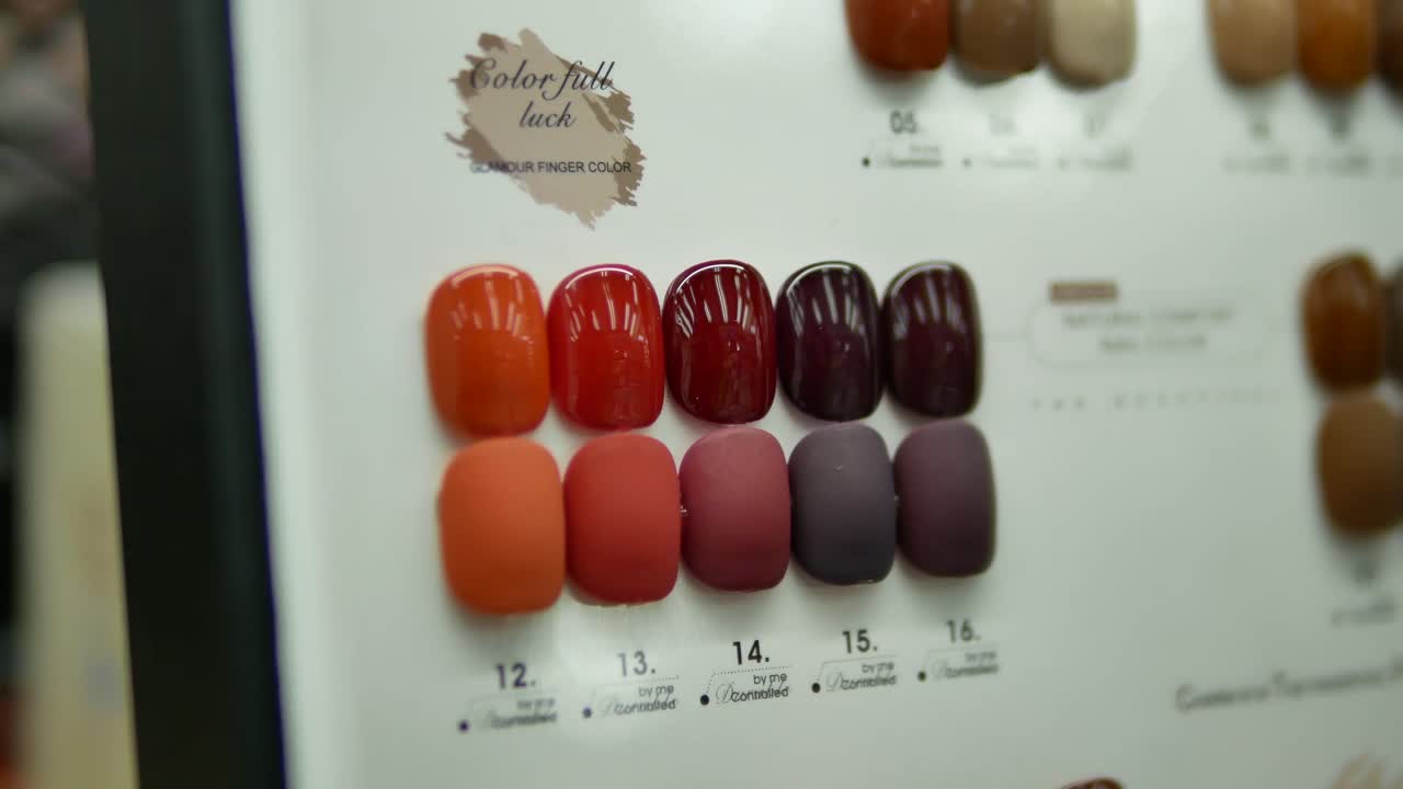 imágenes de primer plano de varios gráficos de colores de uñas que se muestran en la tienda