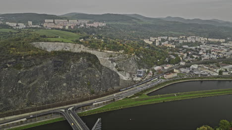 Usti-Nad-Labem-Chequia-Vuelo-Aéreo-V3-Sobre-El-Río-Elba-A-Través-Del-Puente-Mariansky-Most-Hacia-El-Sitio-De-La-Cantera-De-Marianská-Skála,-La-Panorámica-Revela-El-Paisaje-Urbano-De-La-Ladera---Filmado-Con-Cine-Mavic-3---Noviembre-De-2022