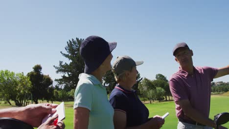 Pareja-Mayor-Caucásica-Discutiendo-Y-Escribiendo-Puntaje-De-Golf-En-El-Cuadro-De-Mando-En-El-Campo-De-Golf