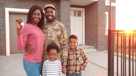 Porträt-Einer-Afroamerikanischen-Familie-Eines-Armeeoffiziers-Mit-Kleinen-Kindern,-Die-In-Ein-Neues-Haus-Ziehen-Und-Schlüssel-Zeigen