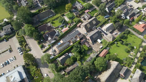 Aerial-of-crane-standing-over-house-under-construction-in-an-old,-classic-neighbourhood