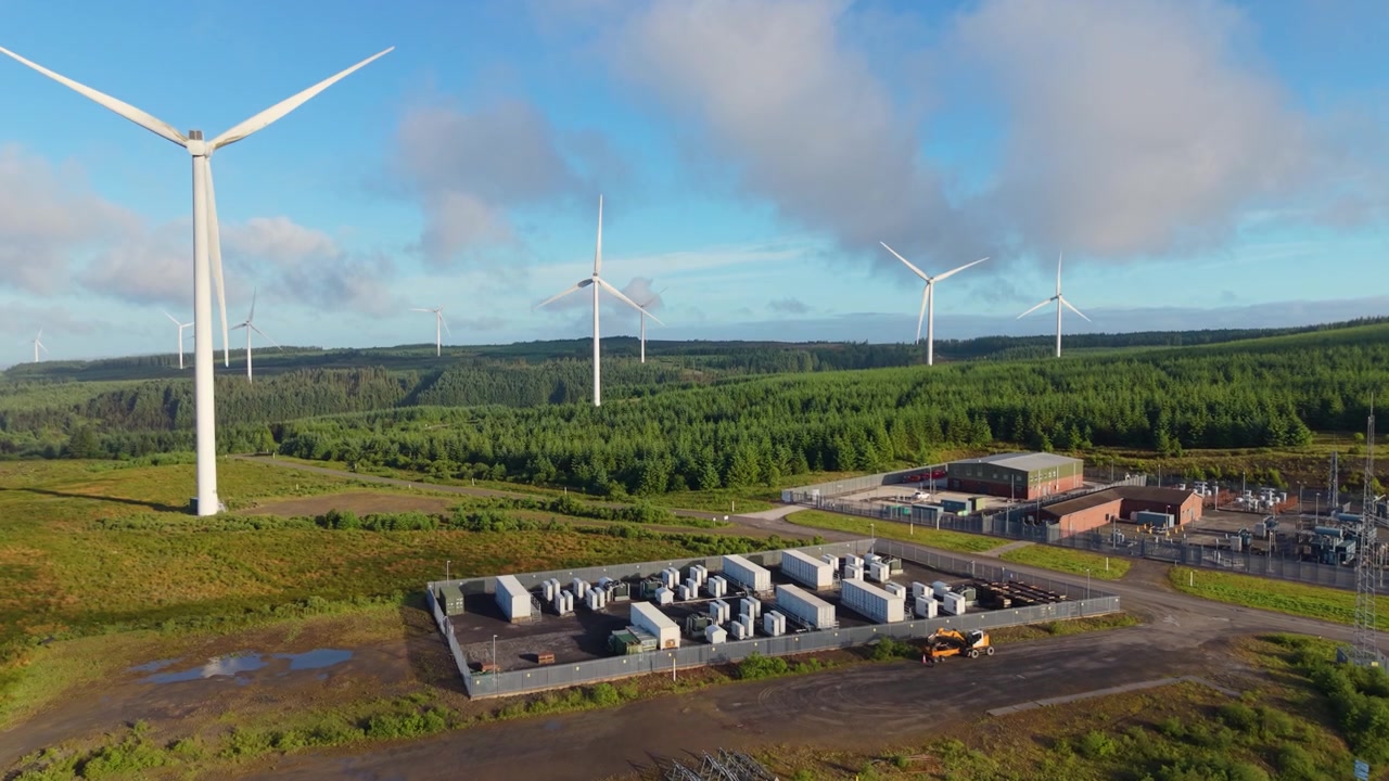 Wide Pushing Shot Towards Wind Farm with BESS Battery Energy Storage System Stockpiling Power for when Wind isn't Blowing.