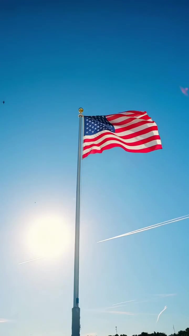 Bandiera americana che sventola su un'asta contro un cielo azzurro brillante