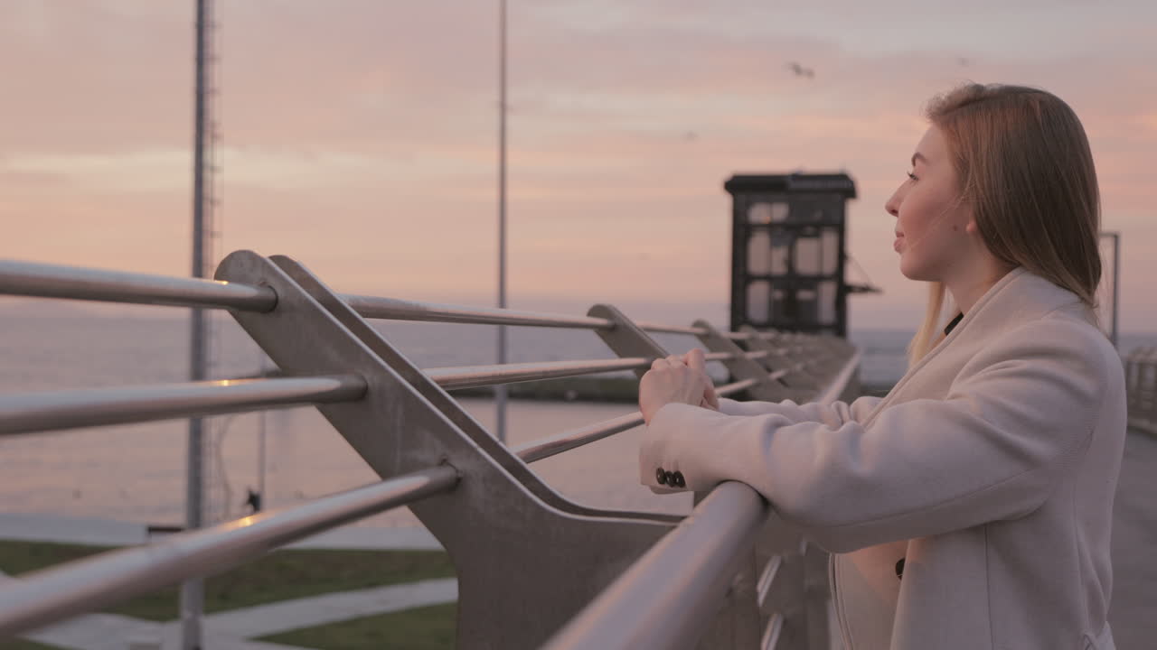 Woman watching the sunset from a bridge