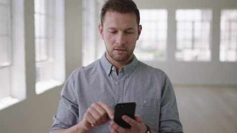 portrait of young caucasian man texting browsing networking using smartphone mobile technology start up business apartment