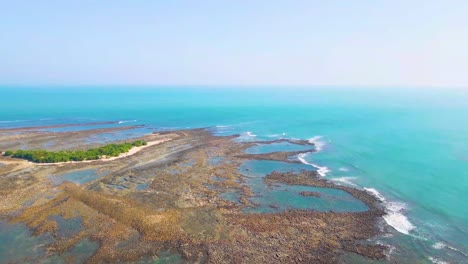 isla rocosa escénica y vacía con una pequeña zona de arbustos verdes en el medio