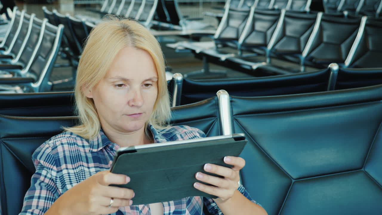 A Woman Uses A Tablet In An Airport Lounge Leisure Pending Flight