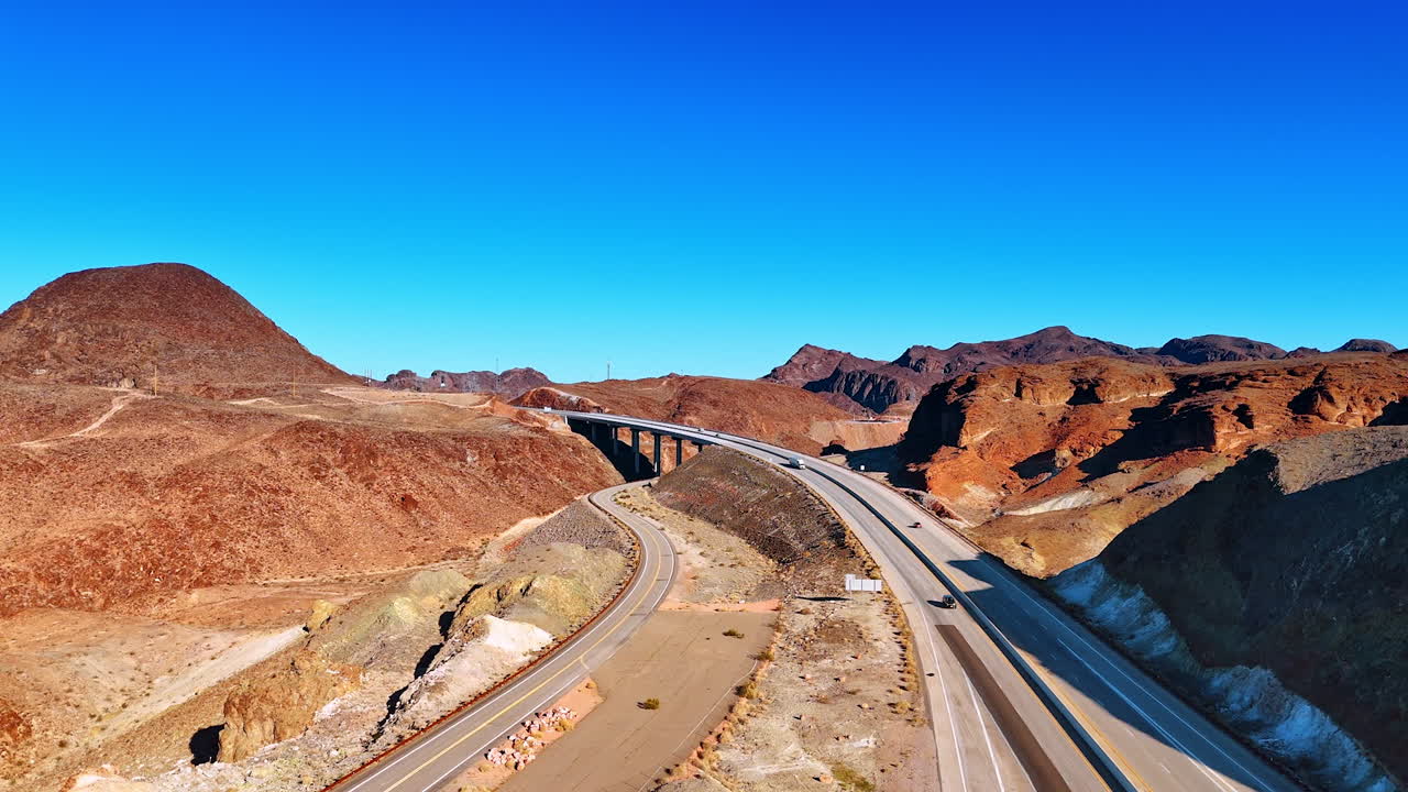 Highways and bridge along the rocky dry landscape. Cars ride by the roads across Arizona, USA at daytime
