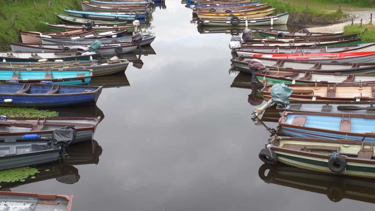 barcos de pesca alineados en la entrada tranquila en el parque nacional de killarney, anillo de kerry, irlanda