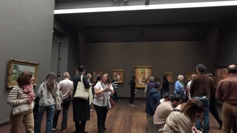 visitors observing paintings in an art gallery