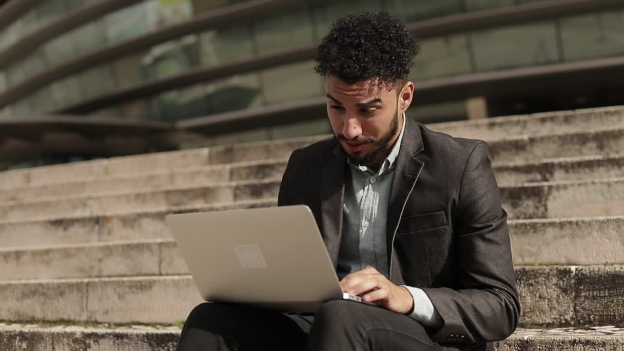 Tired middle eastern young businessman working with laptop