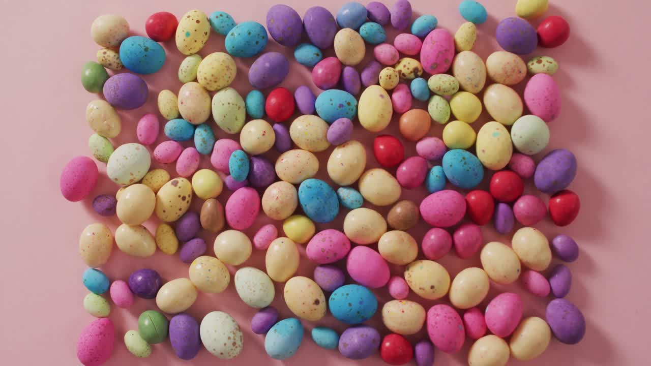 Video of decorated colorful easter eggs on a pink surface