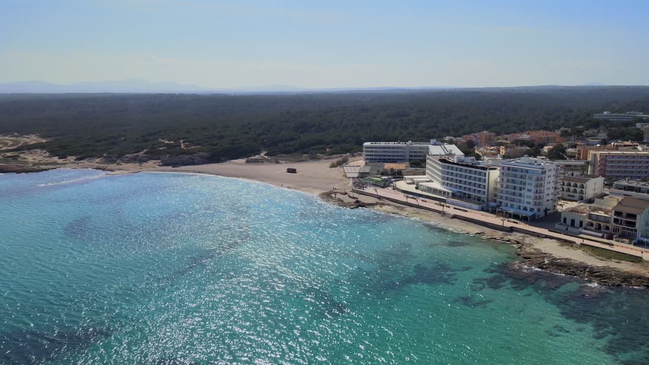 sumérgete en la impresionante perspectiva aérea de la playa de son baulo en can picafort, mallorca. experimenta las aguas cristalinas y la hermosa costa bajo el sol brillante.