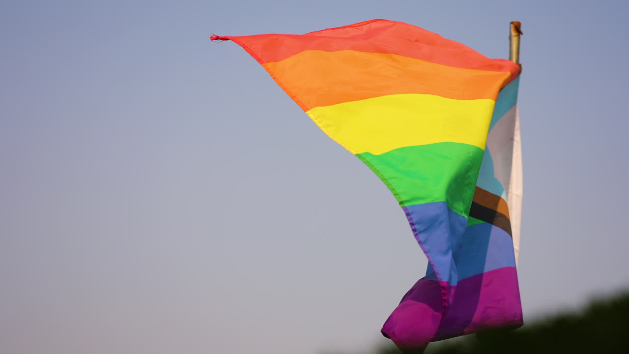 disparo en cámara lenta de una bandera transgénero y lgbtq+ ondeando en el viento