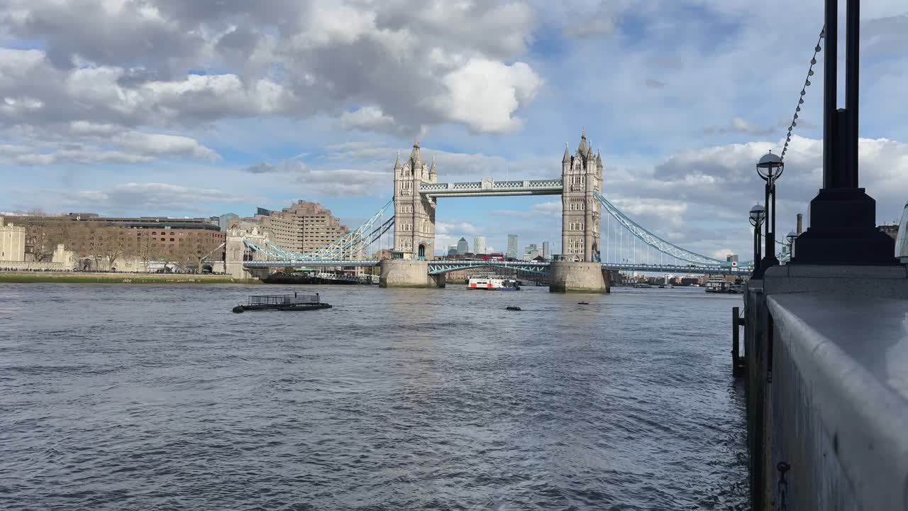 View of Tower Bridge on a cloudy day with boats on the river