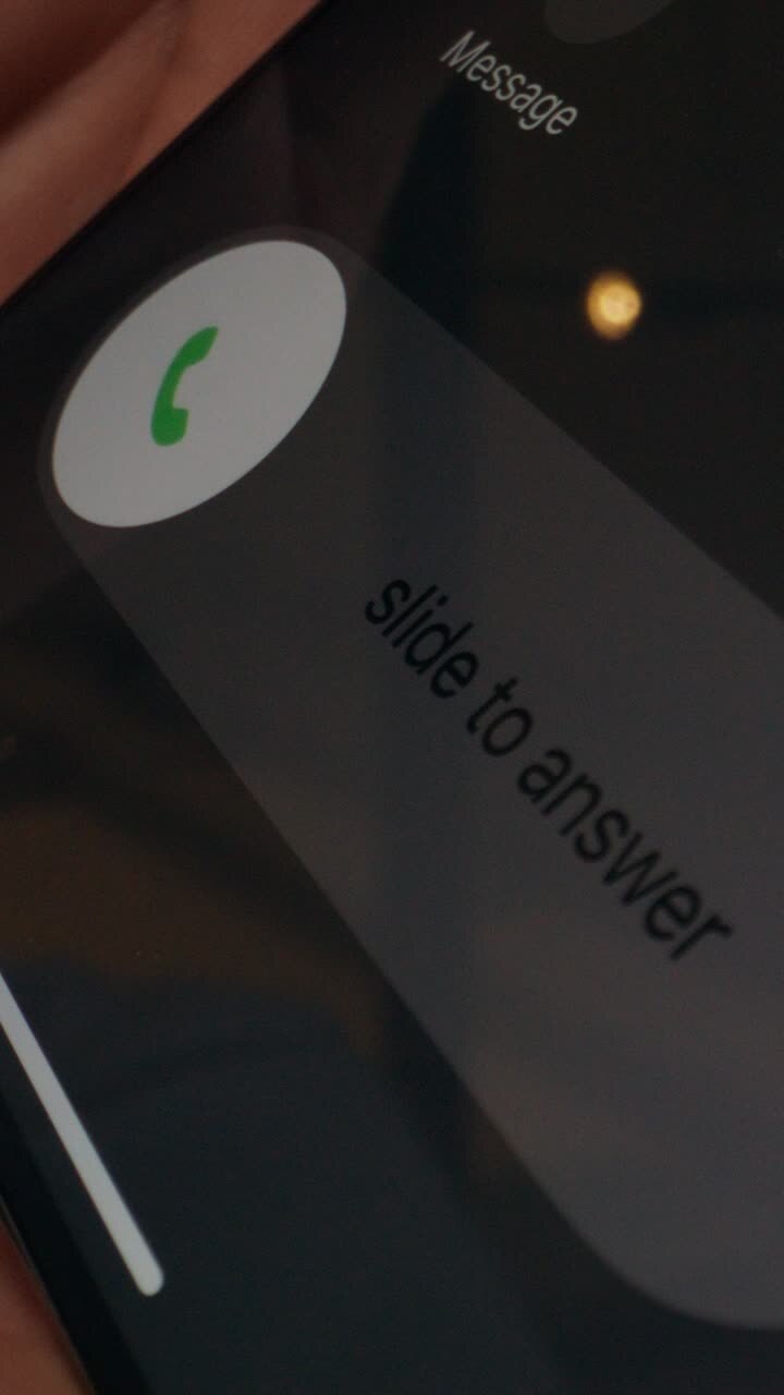 Close-up of finger on touchscreen and a glass of water on a laptop