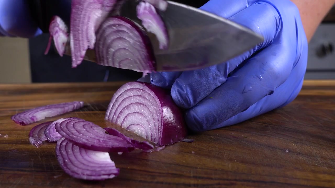 Il cuoco taglia le cipolle su un tagliere