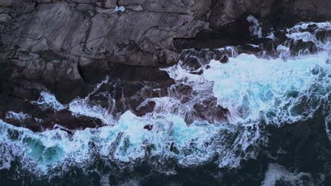 powerful waves crash against rugged rocks at tungeneset beach, senja, norway
