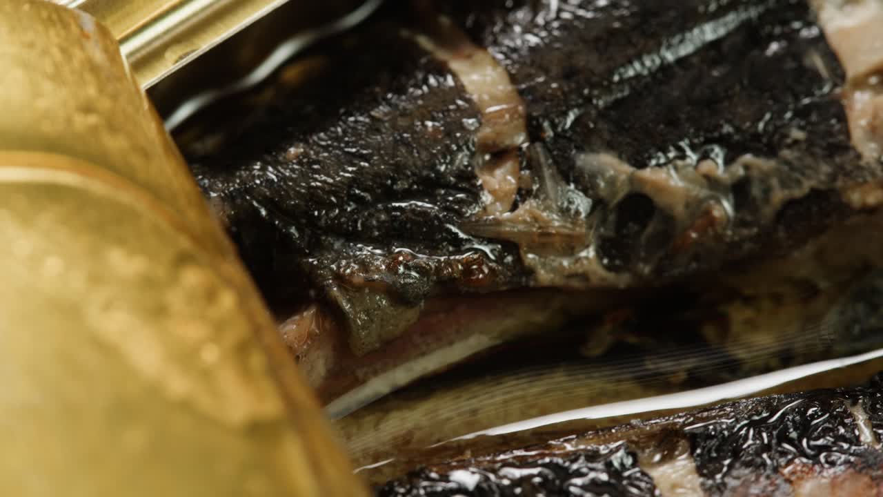 Opening sardine fish or tuna can, man open the canned anchovy on the table. Close up on professional kitchen.